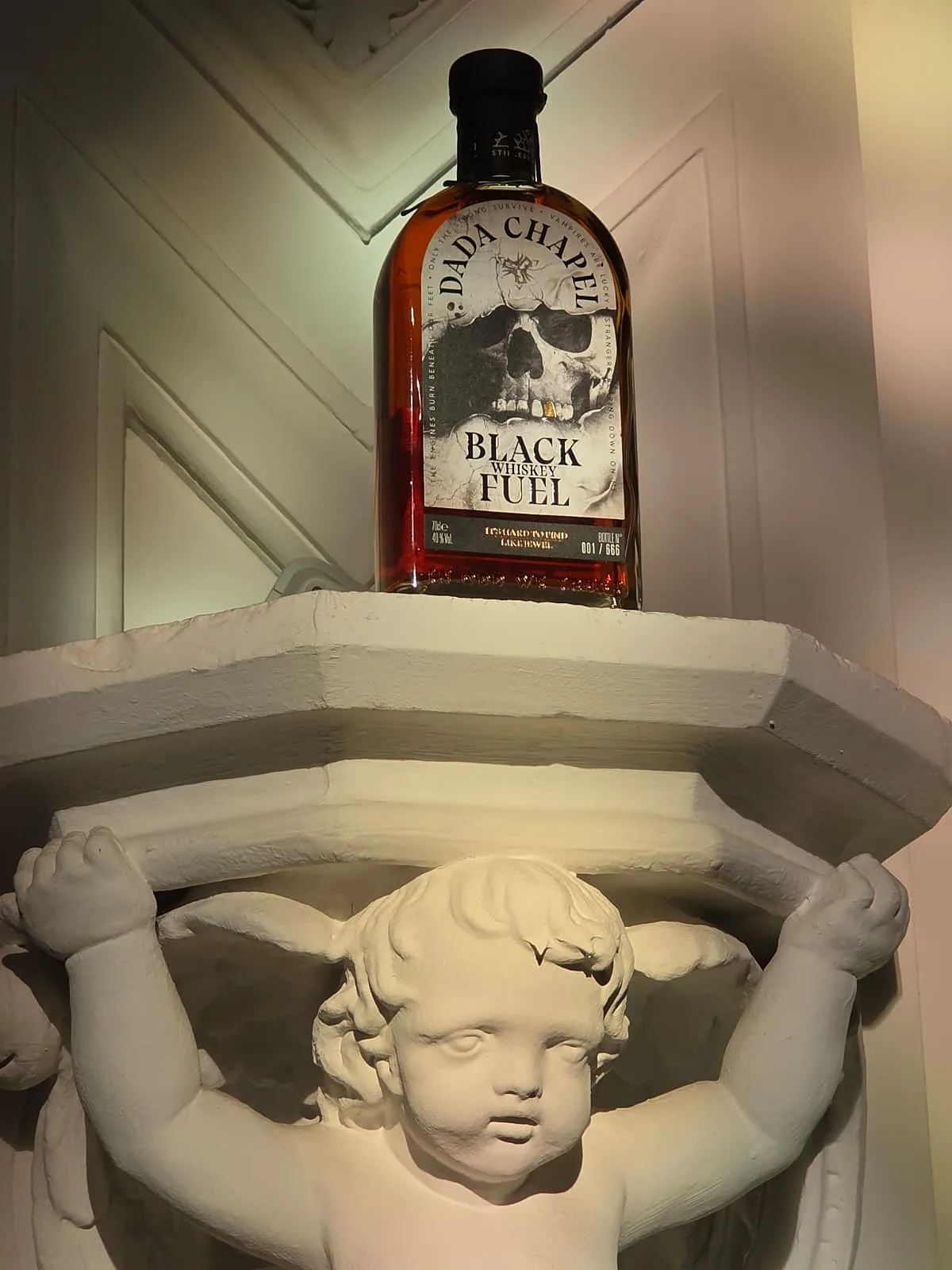Black Fuel fles gedragen door een engelbeeld in de Dada Chapel